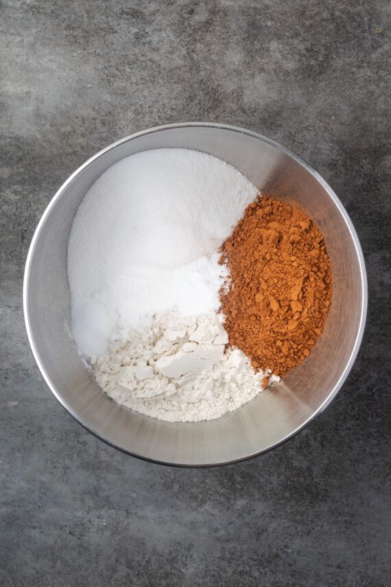 Dry chocolate cake ingredients combined in a metal mixing bowl.
