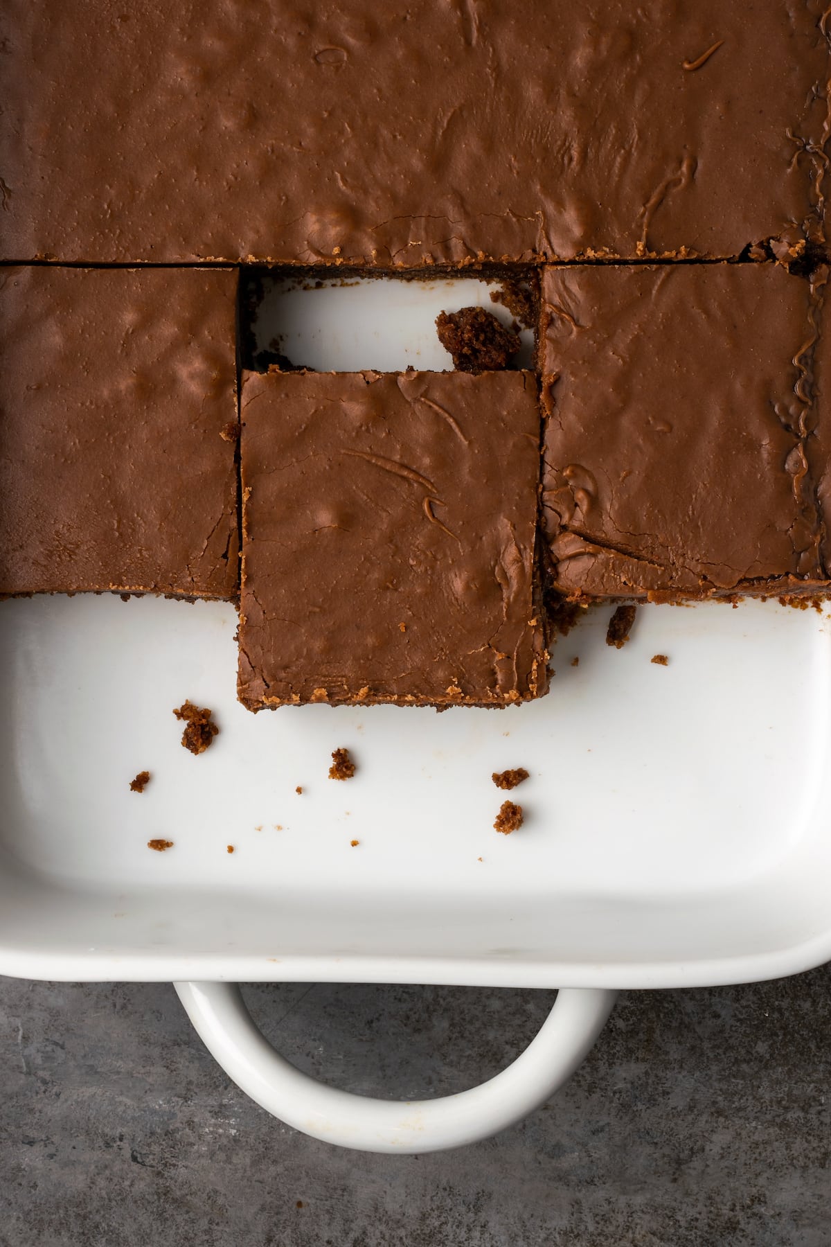 Overhead view of chocolate sheet cake slices in a baking dish.