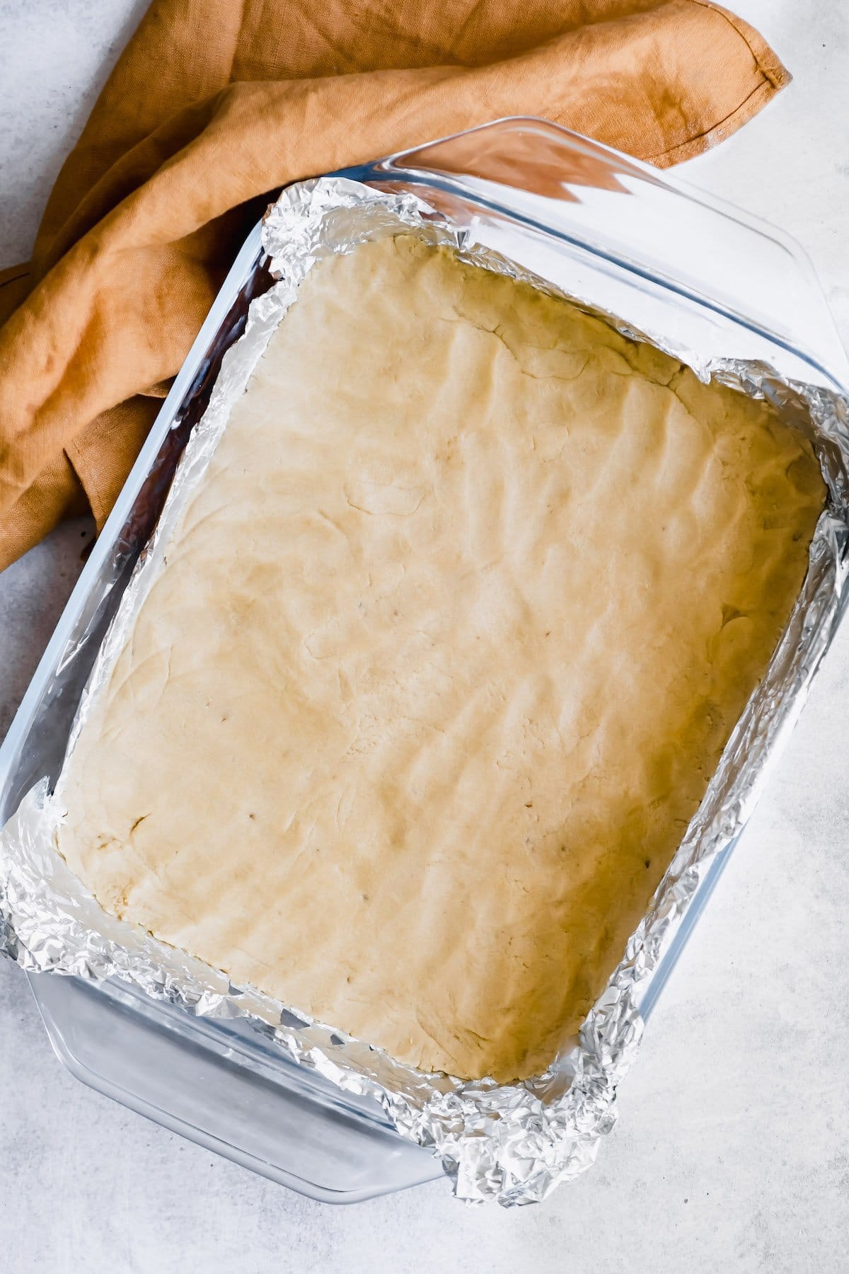 Pressed shortbread dough in a pan.