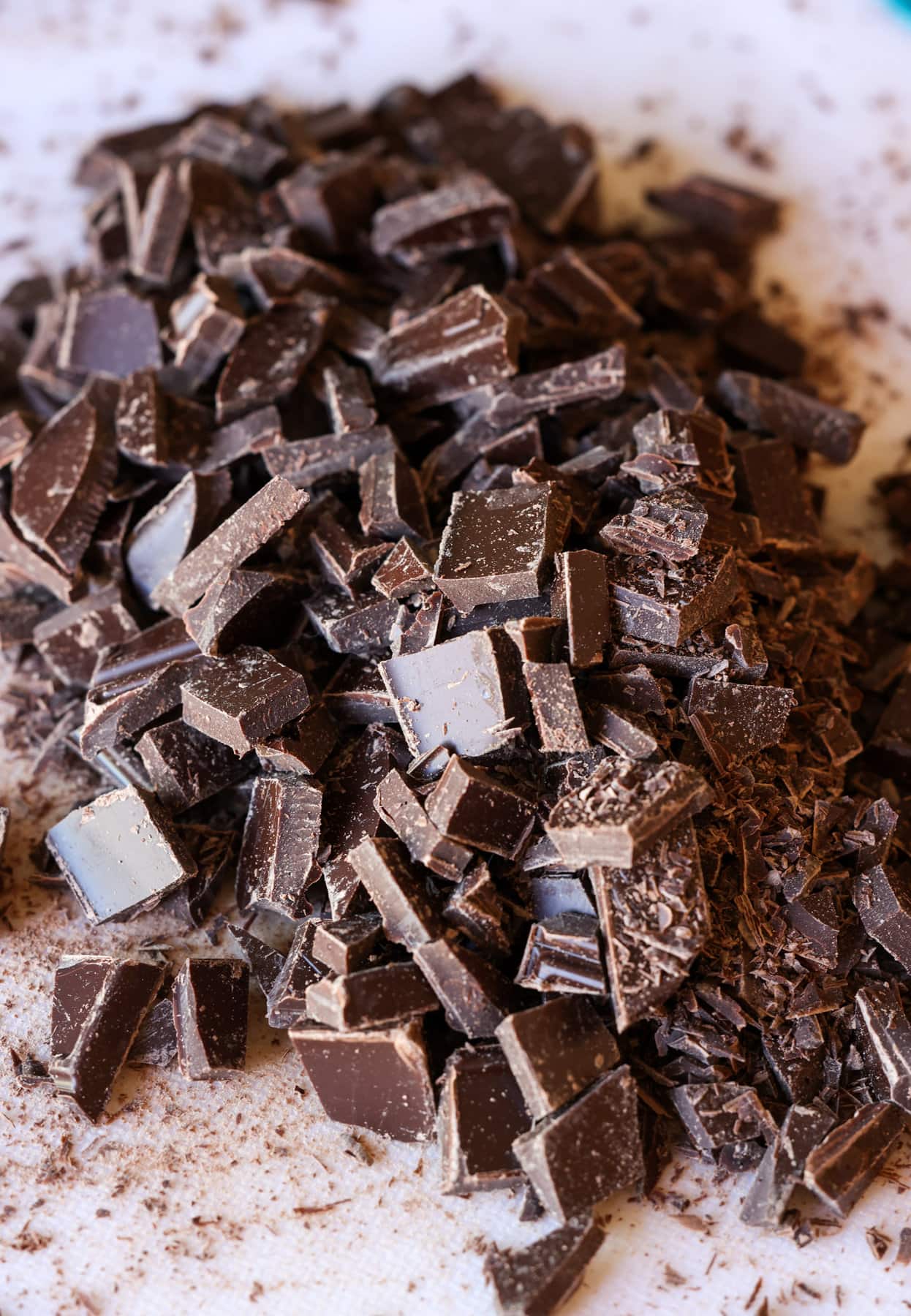 Chocolate Chunks cut up on a white cutting board