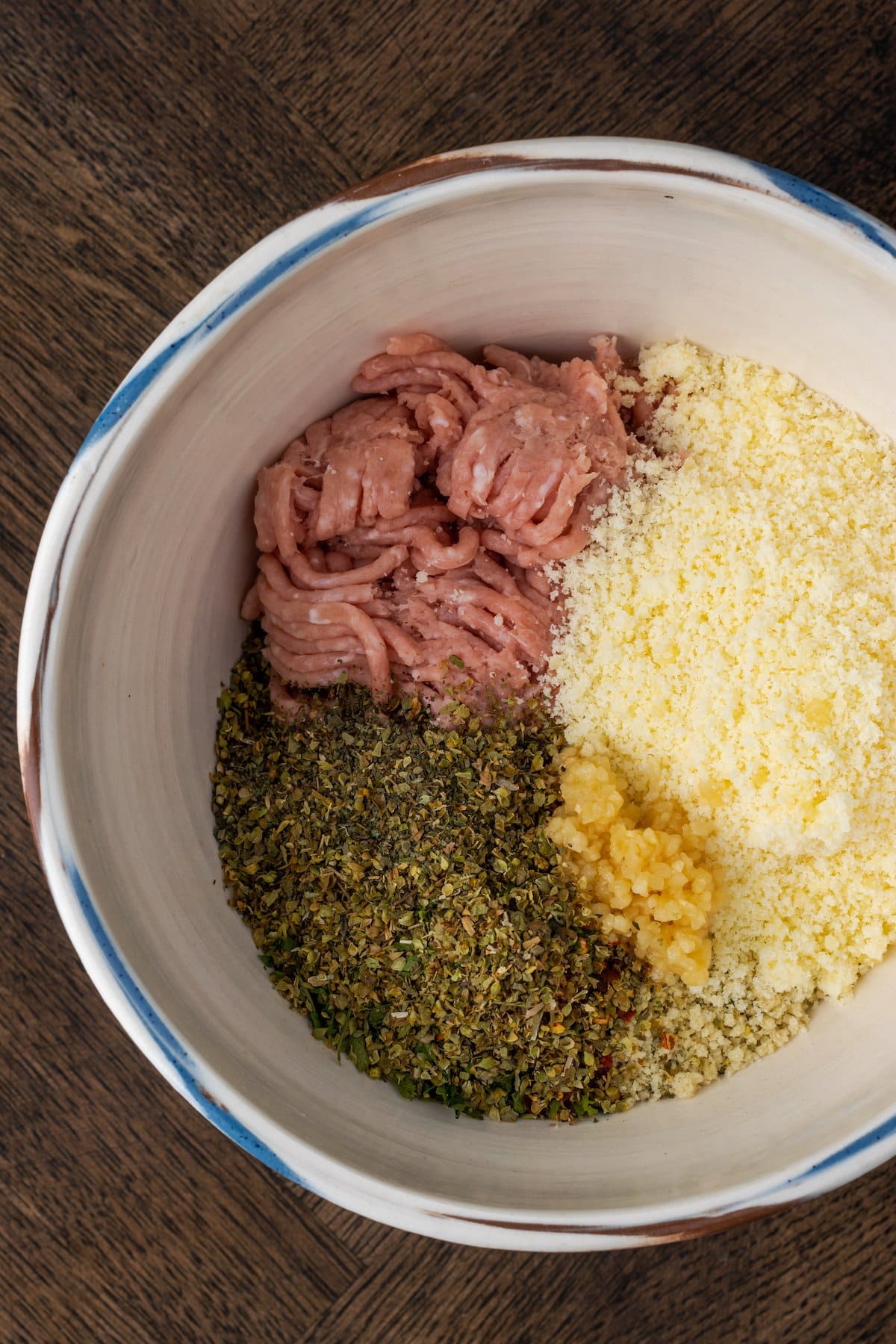 The ingredients for turkey meatballs in a mixing bowl.