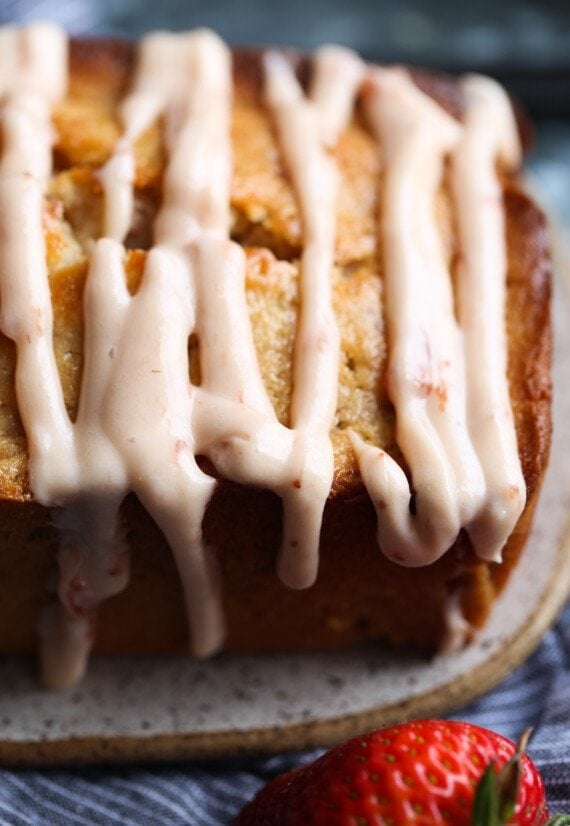 strawberry icing drizzled onto a loaf cake