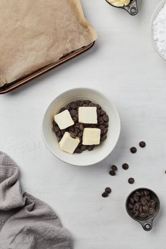 Cubes of butter in a bowl with chocolate chips.