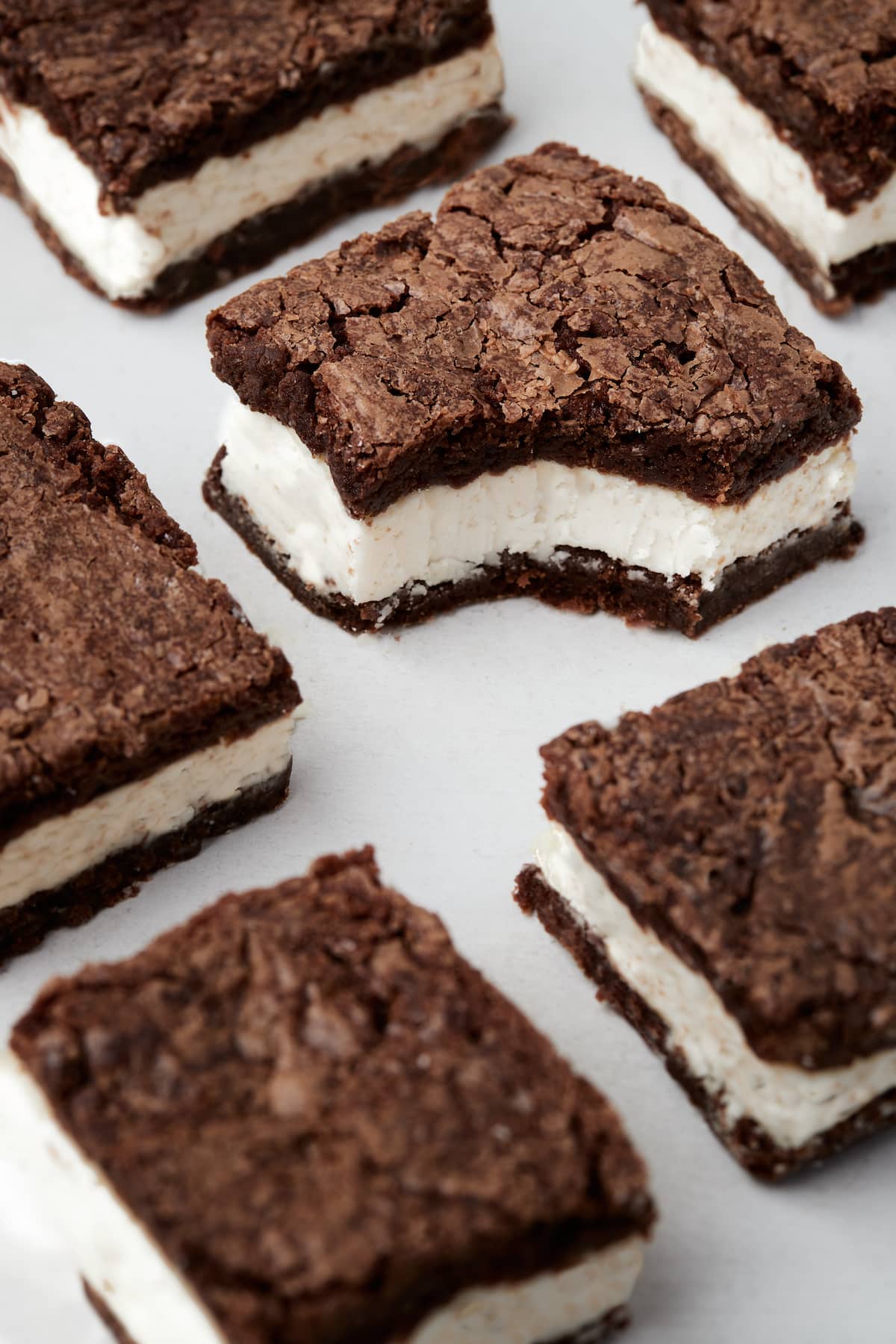 Rows of Oreo brownies cut into squares, one with a bite missing.