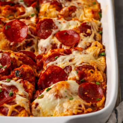 Pizza casserole cut into portions in a baking dish.