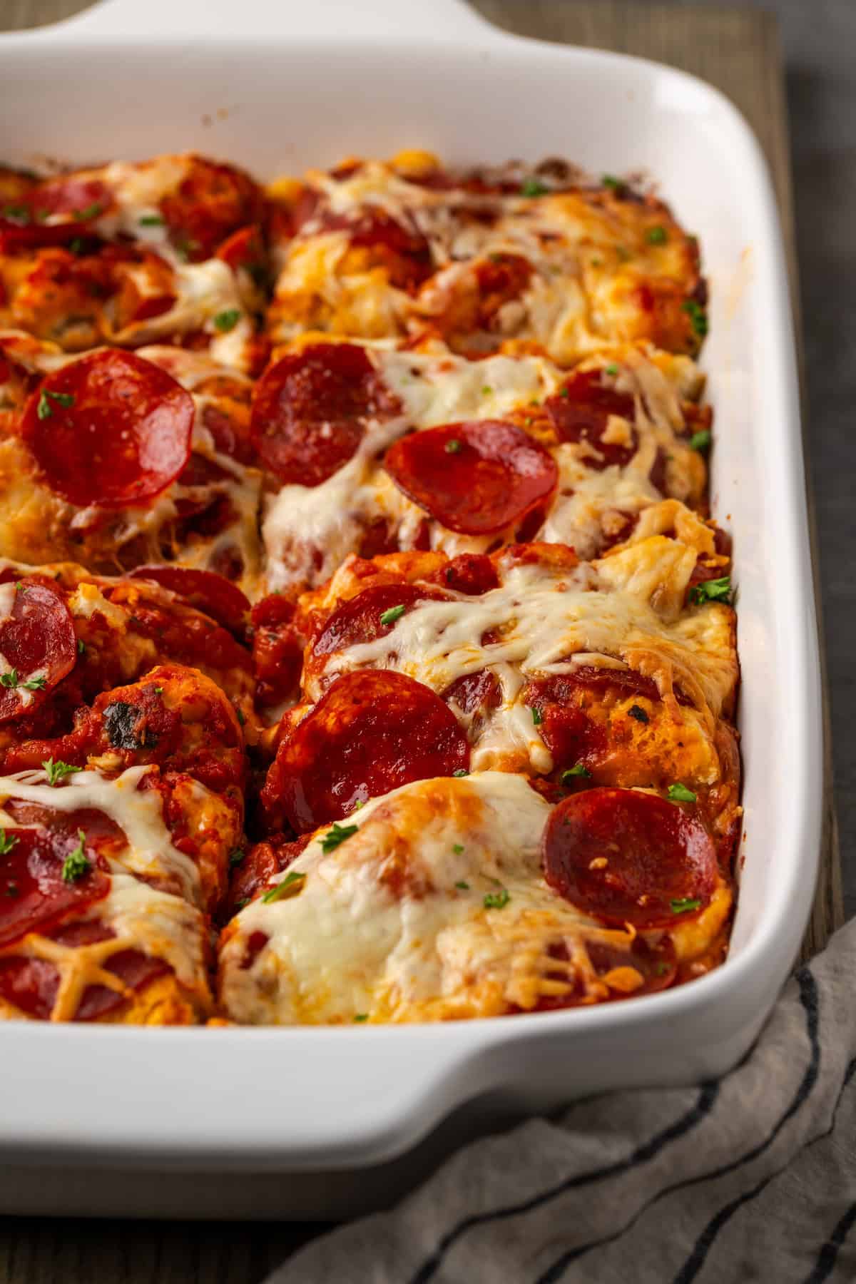 Pizza casserole cut into portions in a baking dish.