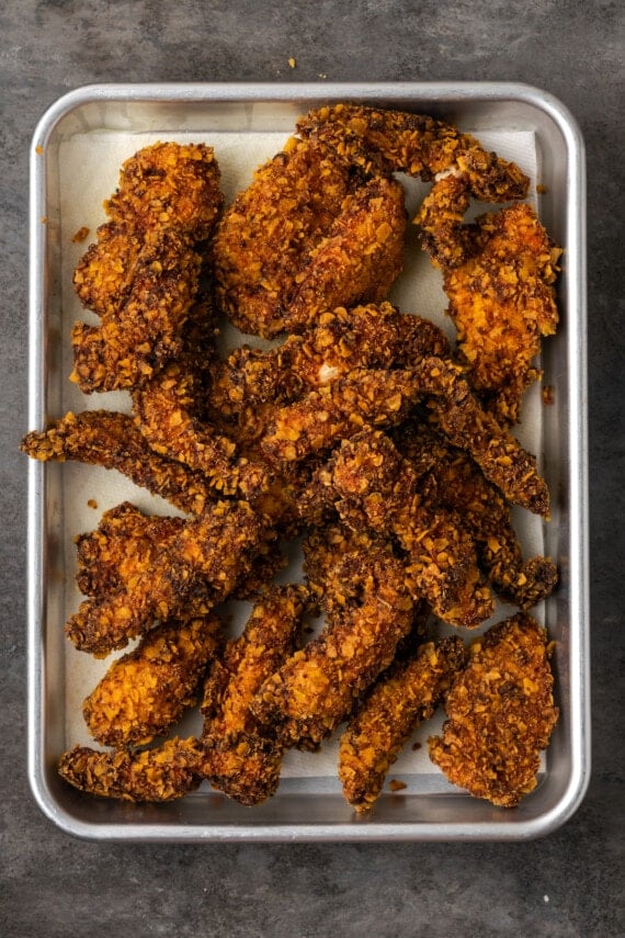 Overhead view of fried ranch chicken tenders on a baking sheet.