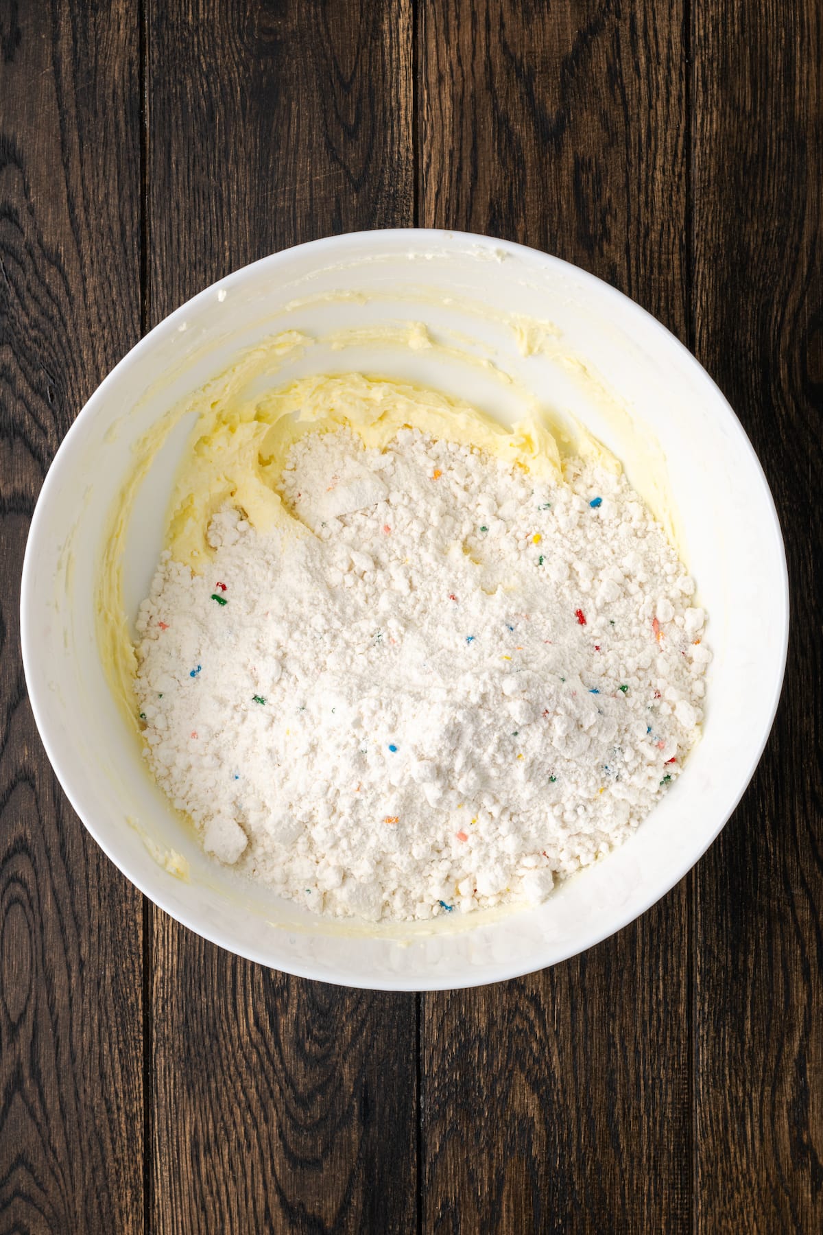 Gooey butter funfetti cookies made with cream cheese, butter, and Funfetti cake mix. These are the best cake mix cookies, and SO easy! Funfetti cake mix added to a bowl with creamed butter and cream cheese.