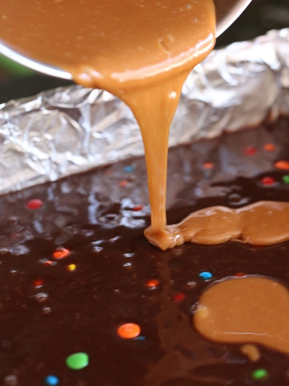 Drizzling the caramel into the brownie batter