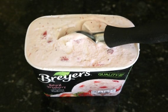 Overhead view of Strawberry Ice Cream container with an ice cream scoop