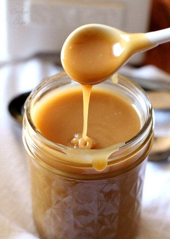 Caramel sauce in a jar with a spoon