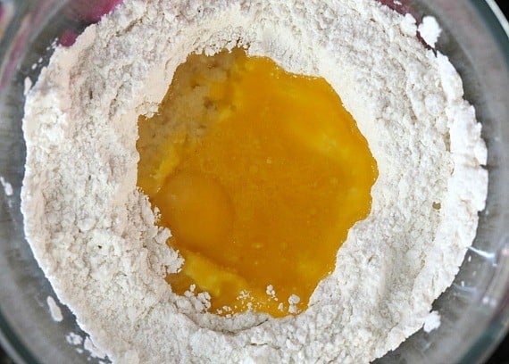 Eggs added to dry cake batter ingredients in a bowl.