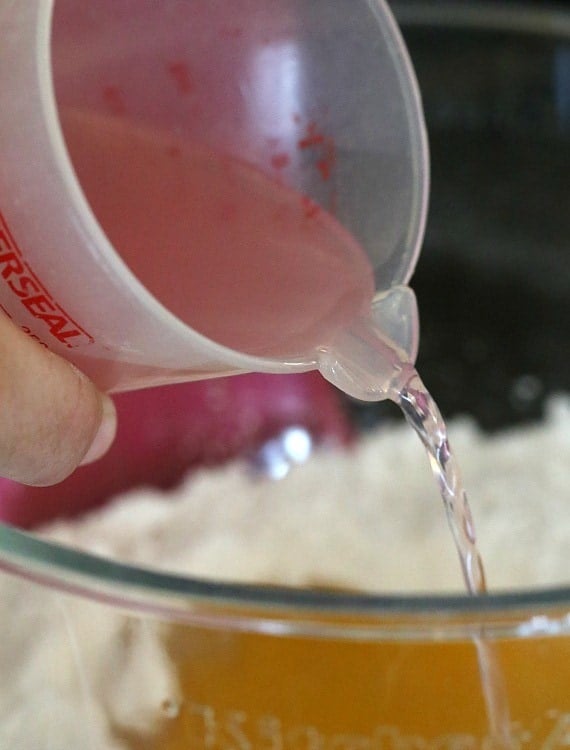 Pouring pink lemonade into the cake batter.