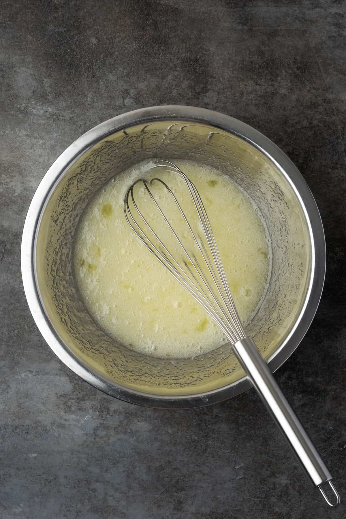 This zesty lemon meringue cheesecake has a smooth and creamy lemon filling, buttery graham cracker crust, and pillows of homemade meringue! Sugar dissolved into egg whites in a double boiler, with a whisk.