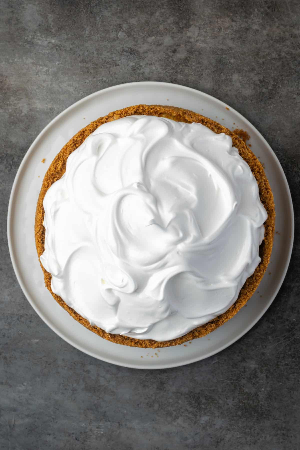 This zesty lemon meringue cheesecake has a smooth and creamy lemon filling, buttery graham cracker crust, and pillows of homemade meringue! Lemon cheesecake topped with meringue.