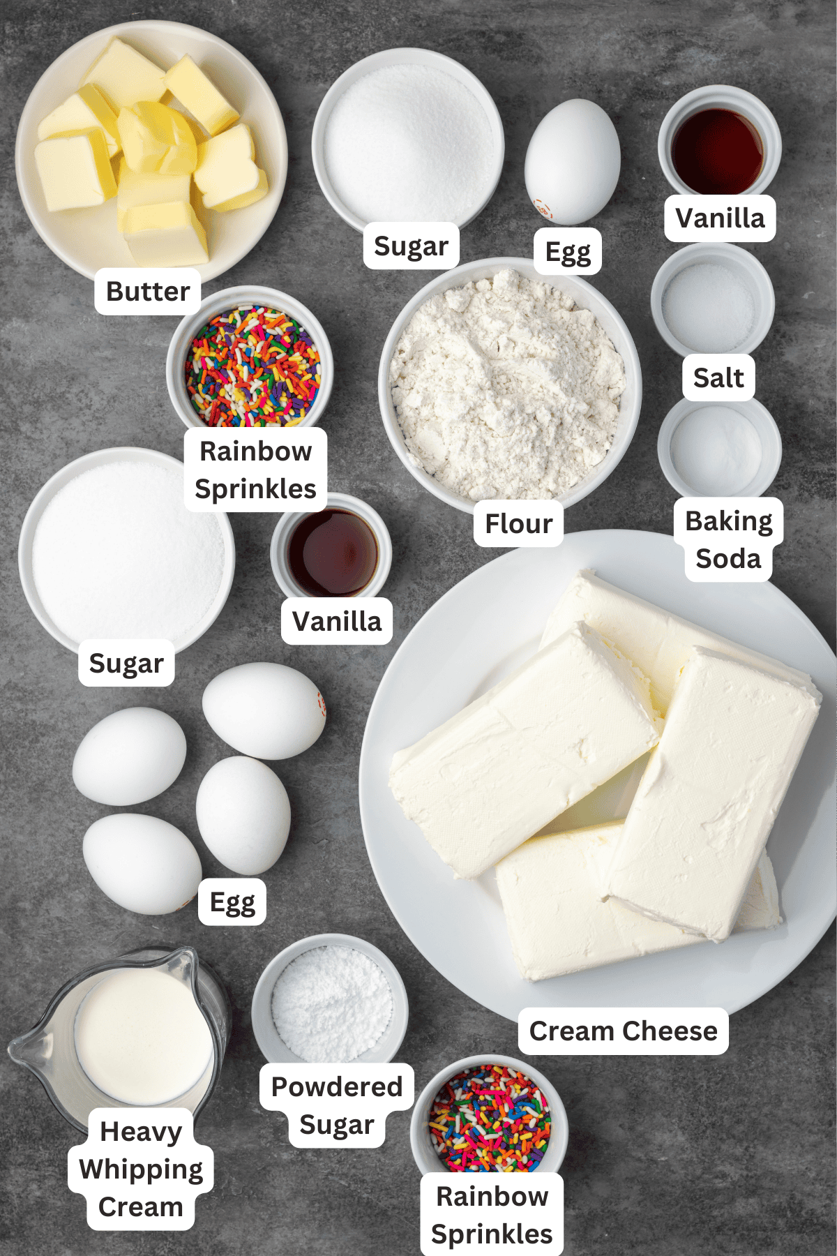 Sugar cookie cheesecake ingredients with text labels overlaying each ingredient.