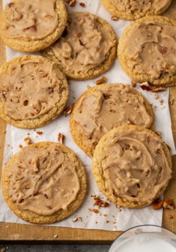 Overhead view of pecan praline cookies on a parchment-lined wooden board.