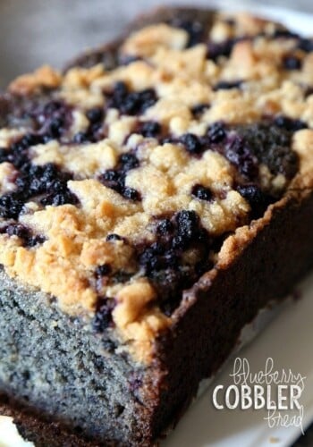 A loaf of blueberry cobbler bread with a slice missing from the end.