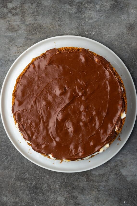 Overhead view of chocolate frosting spread over a brownie pie.