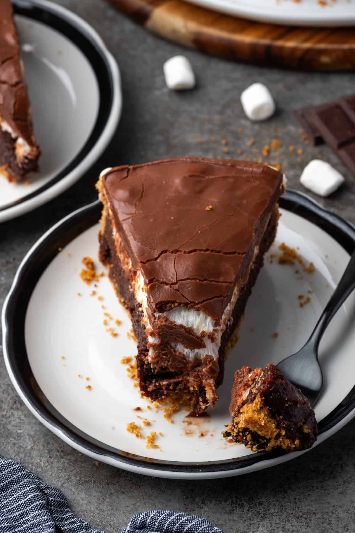 Overhead view of a forkful next a slice of brownie pie on a plate.