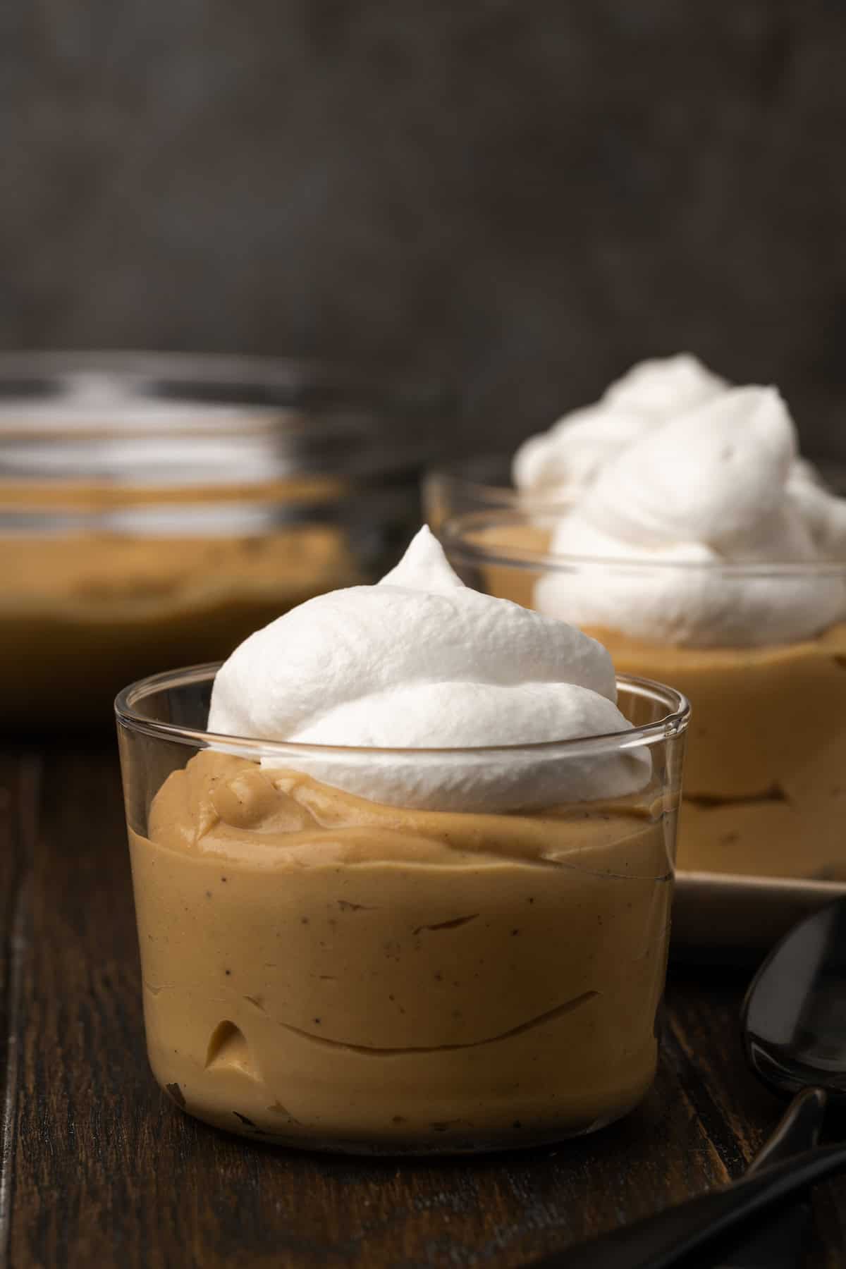 Bourbon butterscotch pudding served in glasses topped with whipped cream.