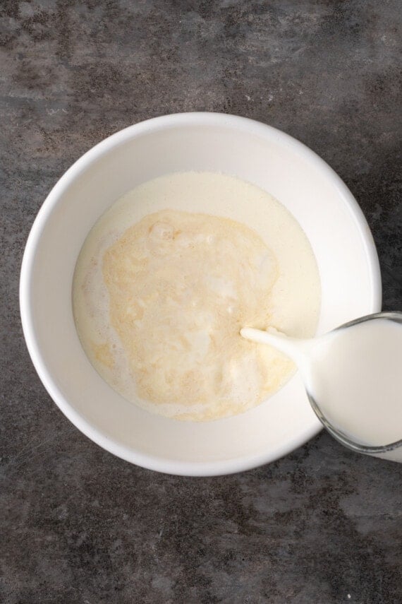 Milk is poured into a bowl of pudding ingredients.