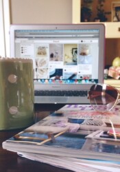 A computer monitor with a mug and a magazine in front