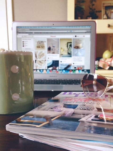 A computer monitor with a mug and a magazine in front