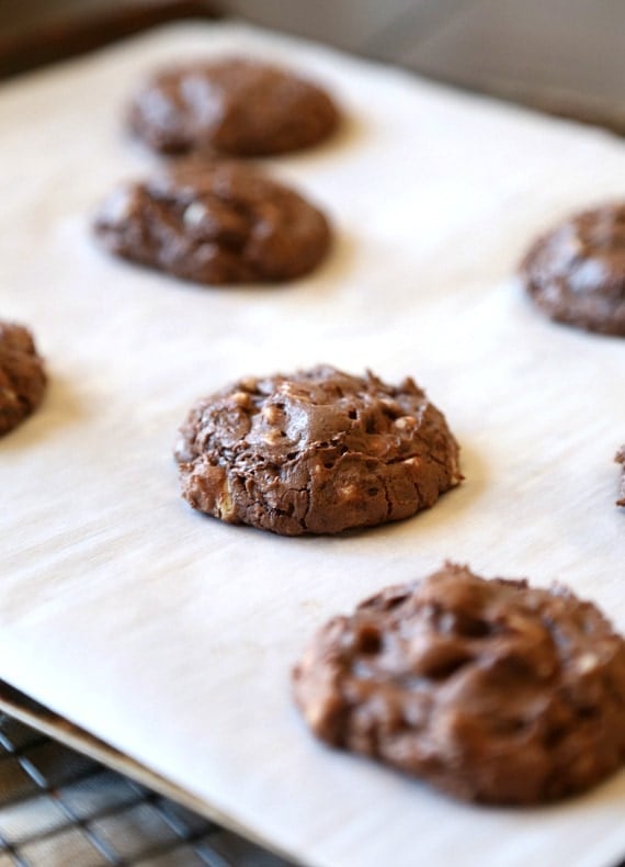 Baked brownie cookies on a parchment lined baking sheet.