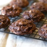 Chocolate cookies with white chocolate chips cooling on a wire rack.
