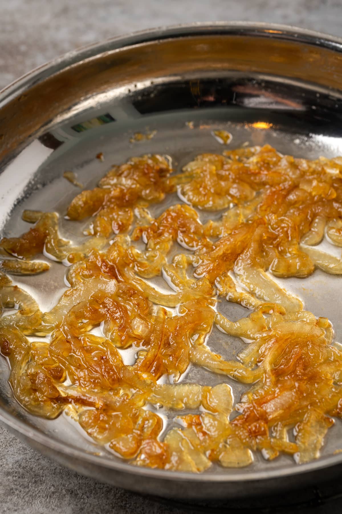 Onion slices caramelizing in a skillet with butter and sugar.