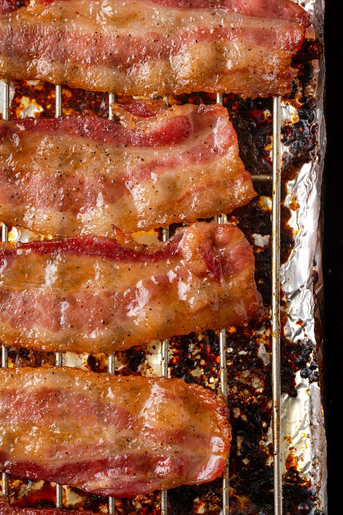 Overhead view of strips of candied bacon lined up on a baking rack.