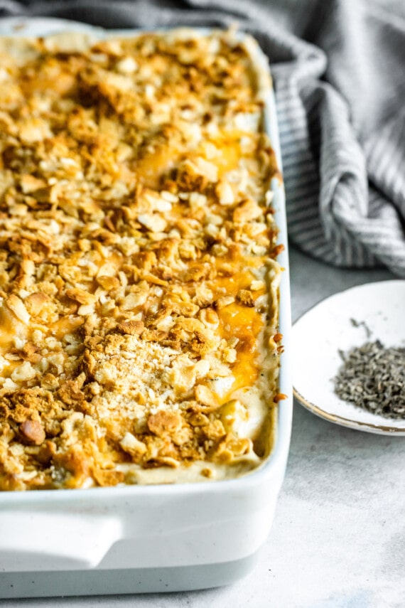 Chicken hashbrown casserole topped with crushed croutons in a large baking dish.