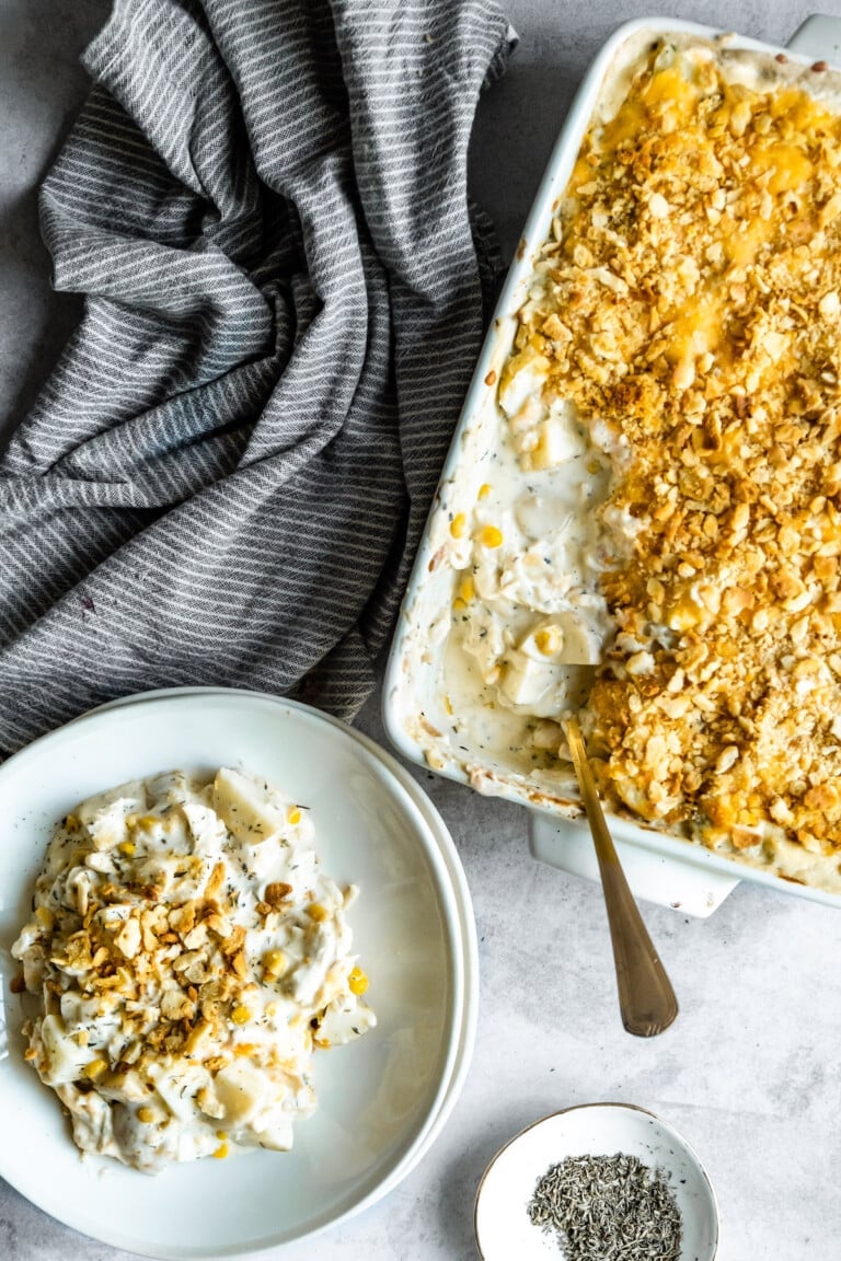 A plate of hash brown casserole next to a casserole dish.