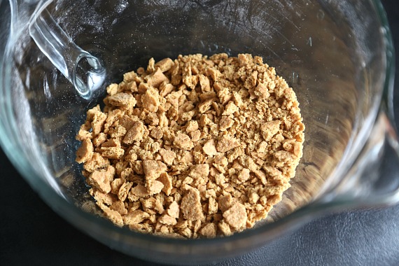 Crushed graham crackers in a glass measuring cup