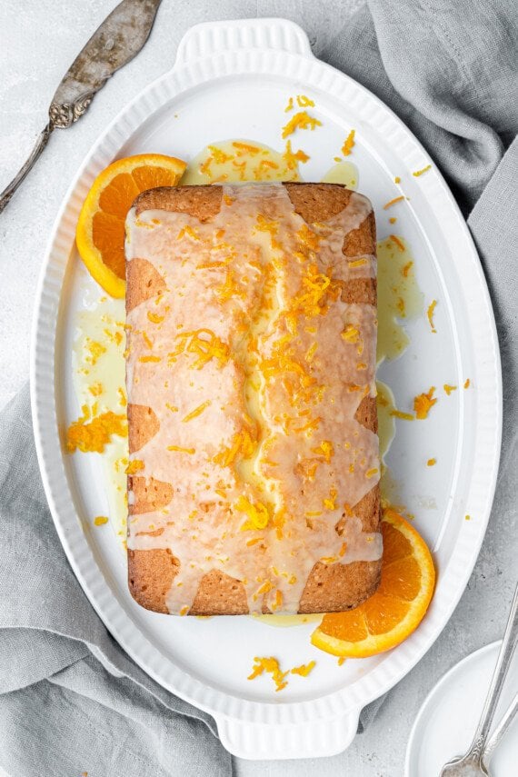 A loaf of orange pound cake with orange slices.