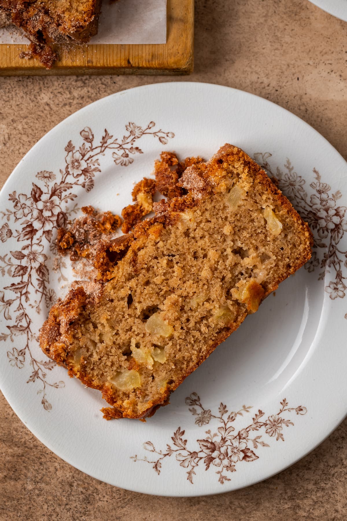 Overhead view of a slice of apple cinnamon bread on a white plate.