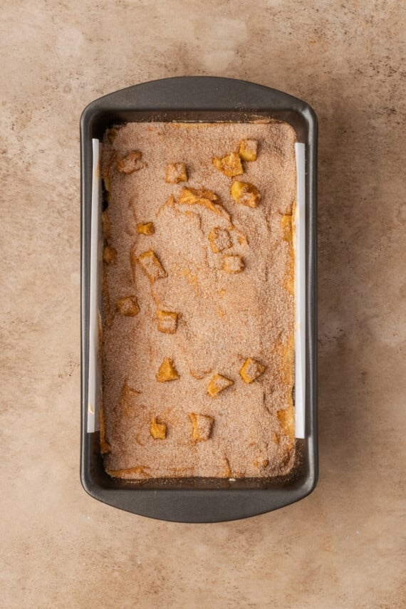 Apple cinnamon bread batter in a parchment-lined loaf pan.