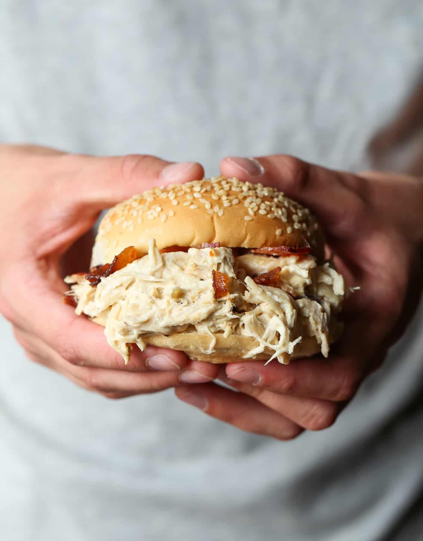 Two hands holding a crack chicken sandwich.