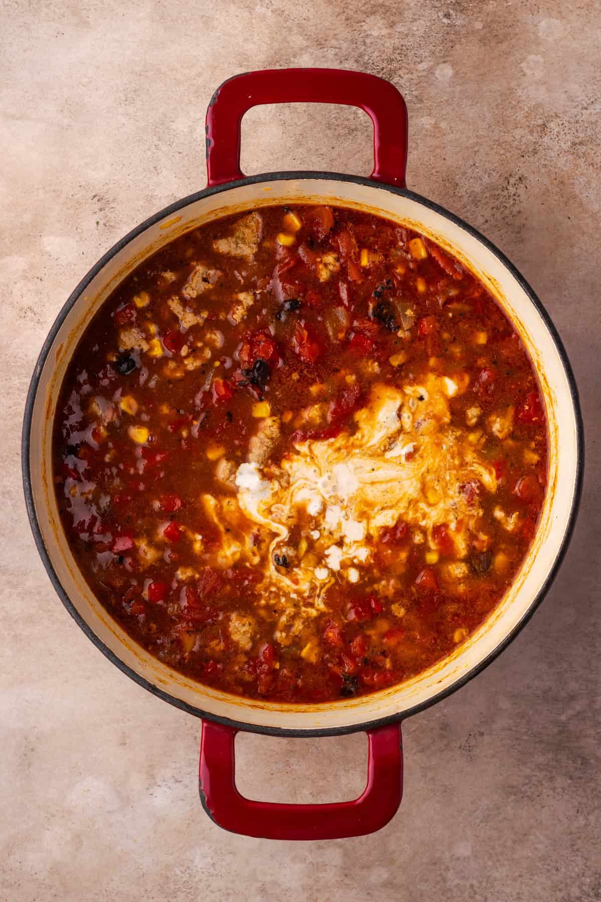 Yogurt and cream cheese mixture added to a pot of taco soup.