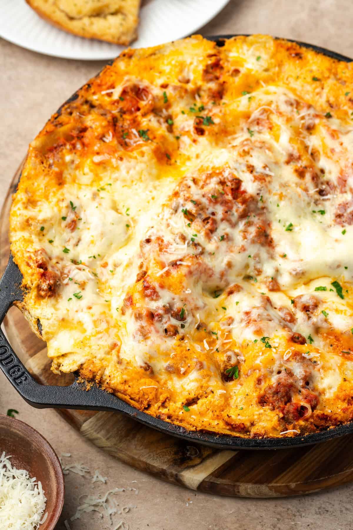 Cooked lasagna in a cast iron skillet.