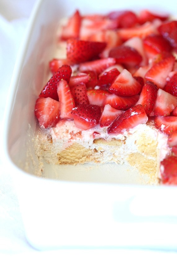 Company strawberry shortcake in a white baking dish with a serving missing.