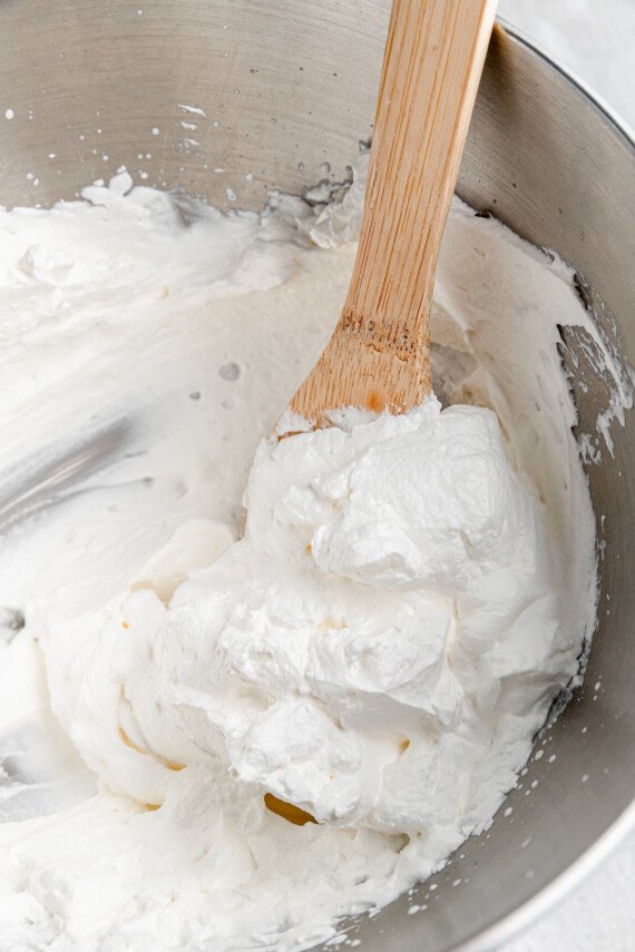Whipped heavy cream in a mixing bowl.