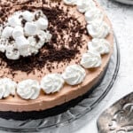 A no bake chocolate pie with whipped cream and an Oreo crust