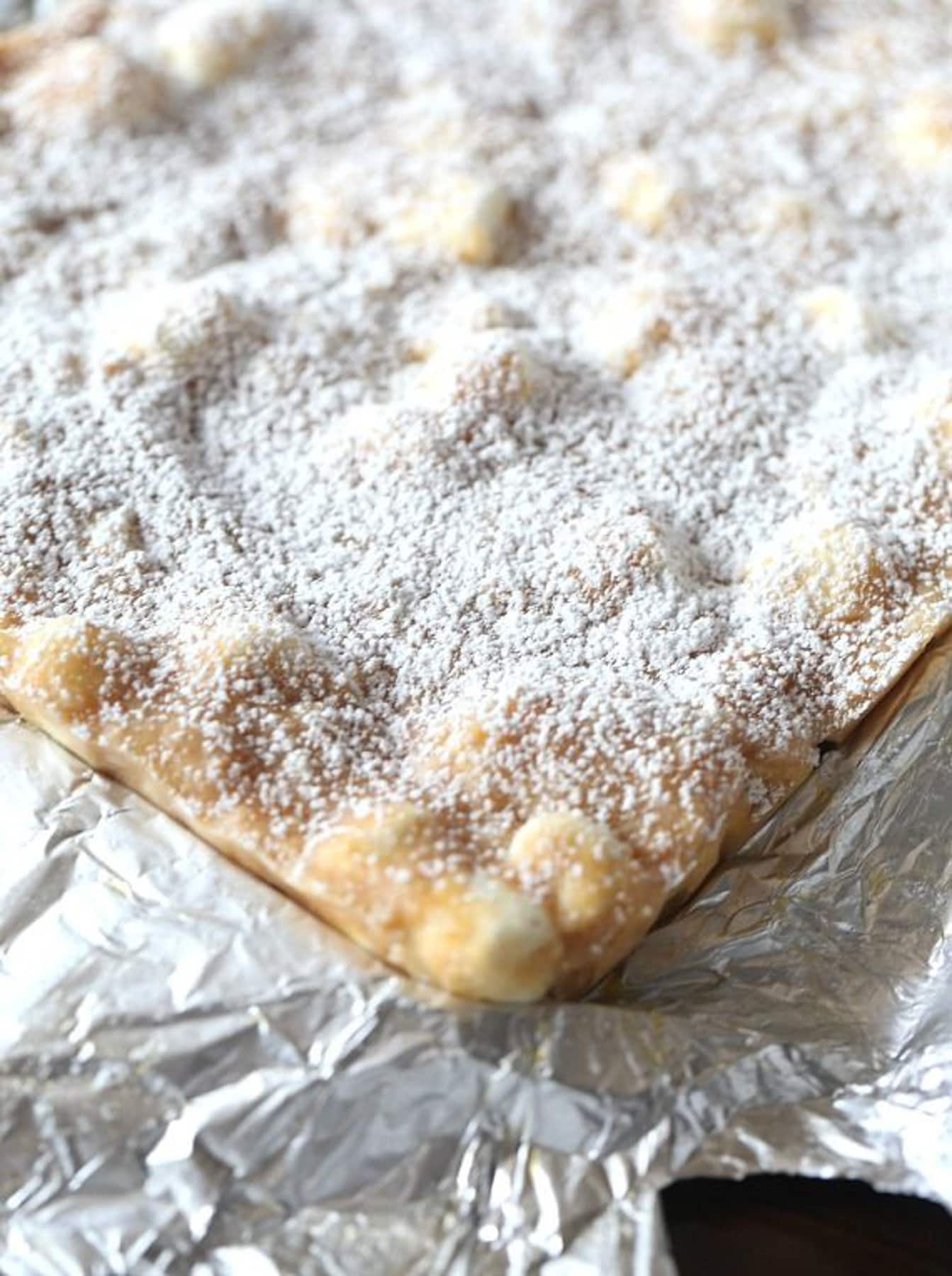 Topping cooled bars with powdered sugar