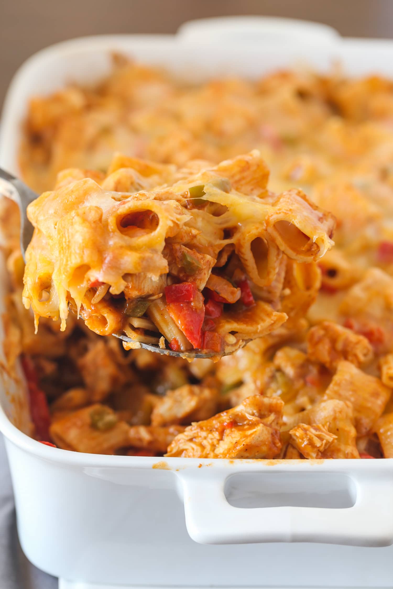 Baked Enchilada Pasta being served with a large spoon from the casserole dish