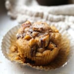 A partially unwrapped French toast muffin in a muffin liner.