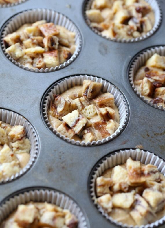 These French toast muffins have custard-soaked French toast pieces baked on top, finished with maple syrup and crunchy cinnamon sugar. French toast mixture pressed on top of muffin batter in a muffin pan.
