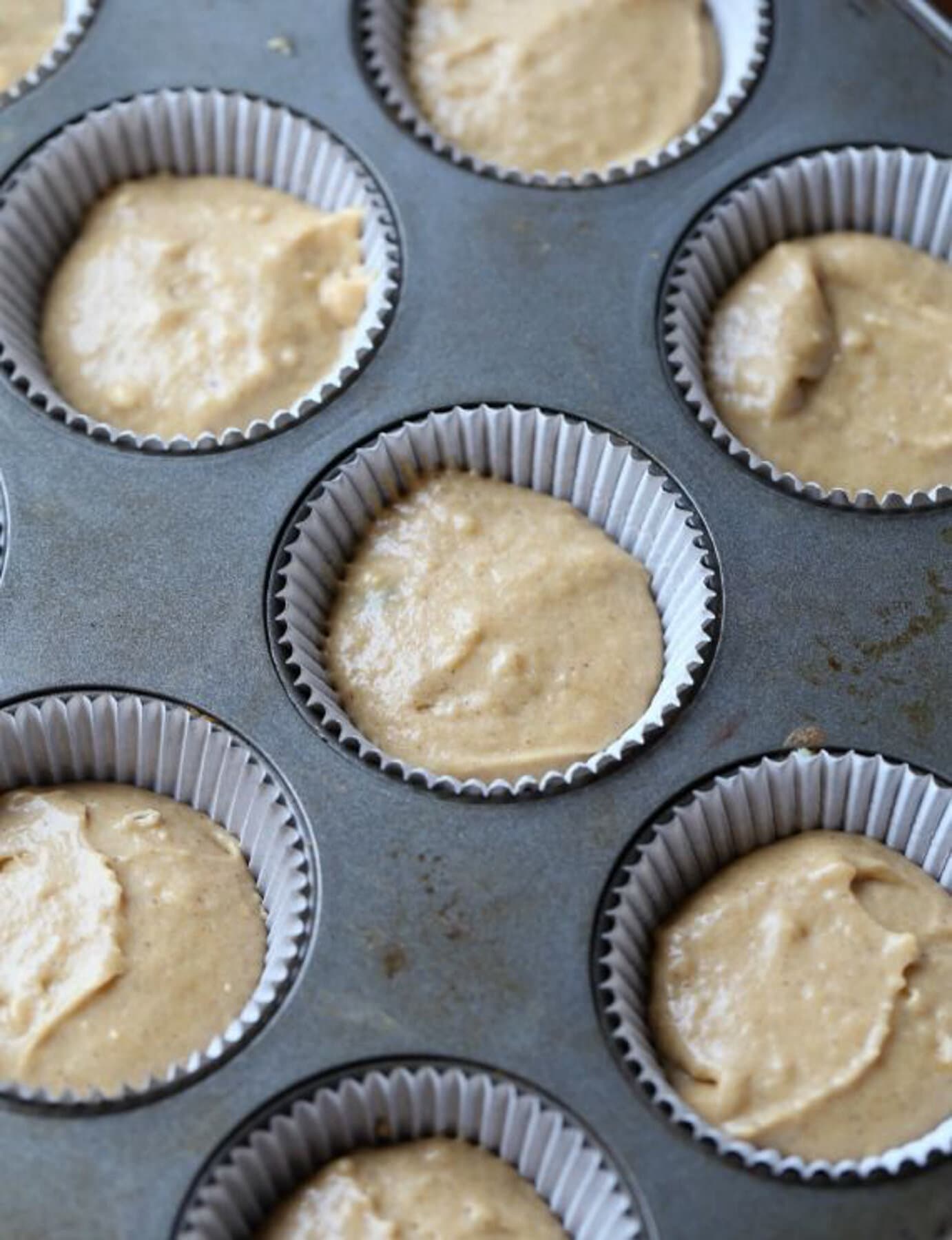 Cinnamon muffin batter filling 2/3s of a muffin tin