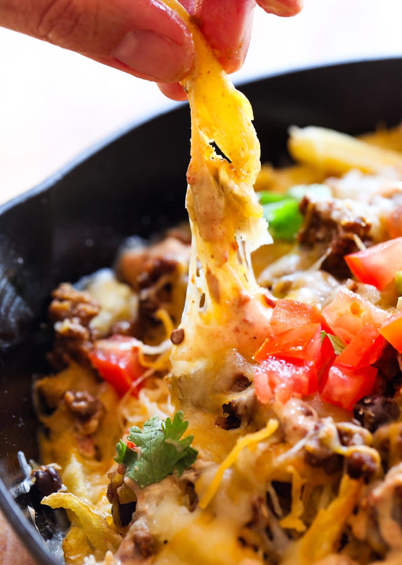 Skillet Frachos showing cheese pull